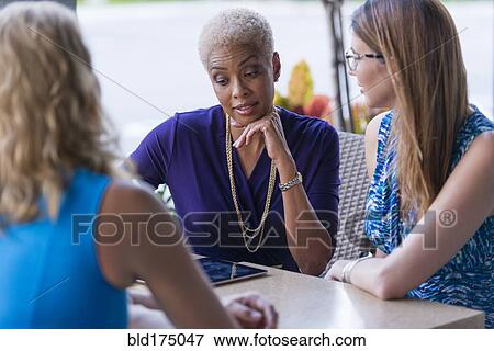 Stock Photo - Businesswomen using digital tablet at table. Fotosearch