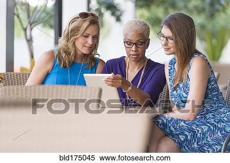 Stock Photography - Businesswomen using digital tablet at table. Fotosearch