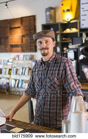 Stock Photo - Caucasian barista working in cafe. Fotosearch