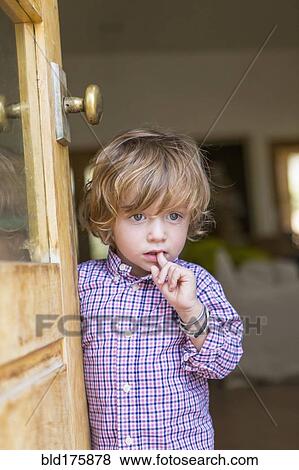 Stock Photo - Caucasian boy looking out open door. Fotosearch
