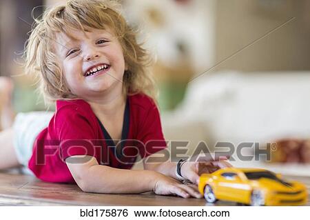 Stock Photograph - Caucasian boy playing with toy car. Fotosearch