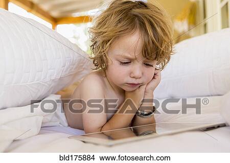 Picture - Caucasian boy using digital tablet. Fotosearch