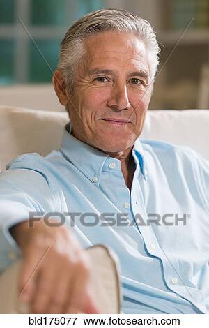 Stock Photo - Caucasian businessman smiling on sofa. Fotosearch