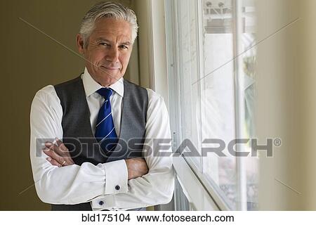 Caucasian businessman standing at window View Large Photo Image Picture - Caucasian businessman standing at window. Fotosearch