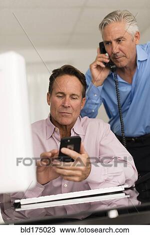 Caucasian businessmen working at desk View Large Photo Image Stock Image - Caucasian businessmen working at desk. Fotosearch