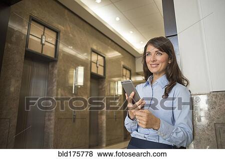 Stock Photo - Caucasian businesswoman using cell phone. Fotosearch