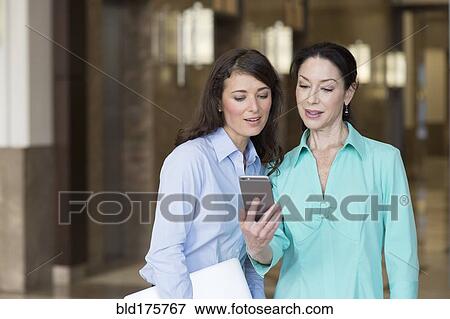 Caucasian businesswomen using cell phone View Large Photo Image Stock Photo - Caucasian businesswomen using cell phone. Fotosearch