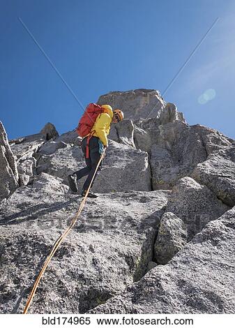 Stock Photography - Caucasian climber on mountainside. Fotosearch