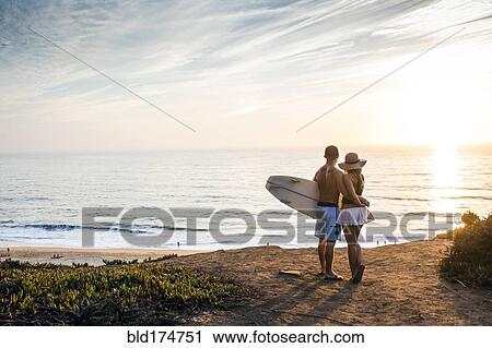 Stock Image - Caucasian couple admiring seascape at beach. Fotosearch