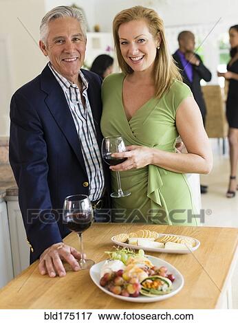 Stock Photo - Caucasian couple drinking wine at party. Fotosearch