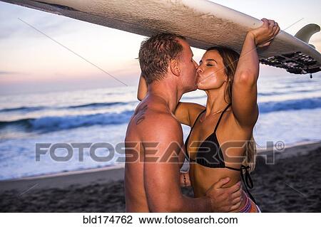 Stock Image - Caucasian couple kissing on beach. Fotosearch