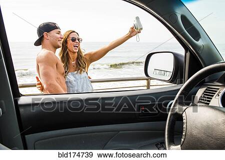 Caucasian couple taking selfie at beach View Large Photo Image Stock Photo - Caucasian couple taking selfie at beach. Fotosearch