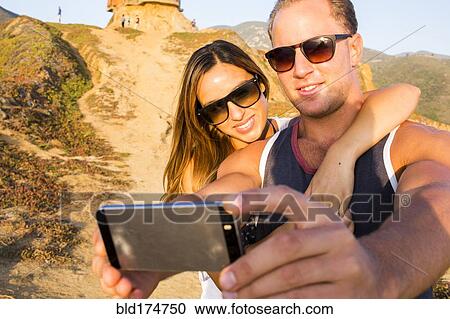 Stock Image - Caucasian couple taking selfie. Fotosearch