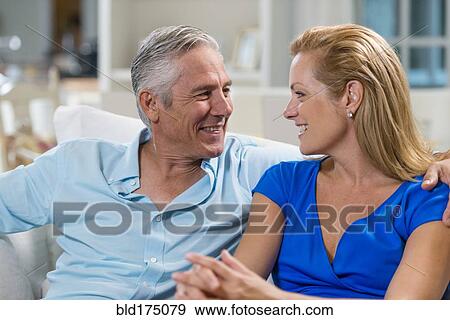 Stock Photo - Caucasian couple talking on sofa. Fotosearch