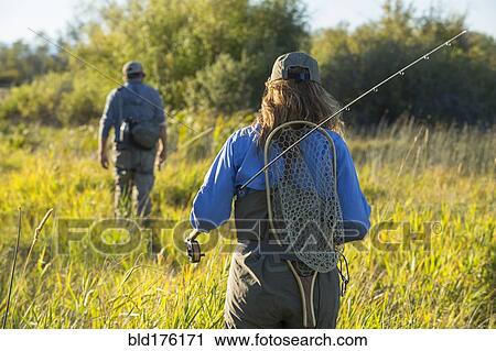 Caucasian couple with fishing gear in field View Large Photo Image Stock Image - Caucasian couple with fishing gear in field. Fotosearch