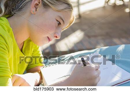 Stock Image - Caucasian girl drawing outdoors. Fotosearch
