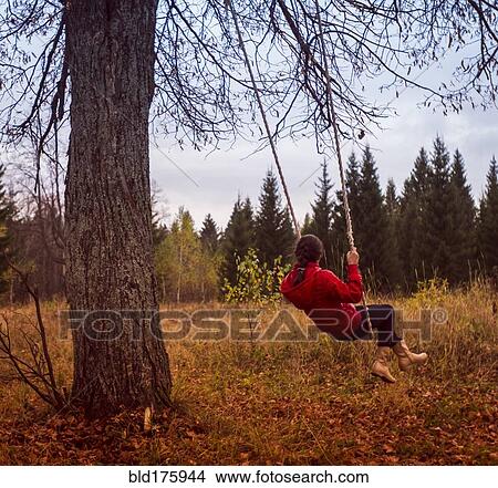 Picture - Caucasian girl playing on swing. Fotosearch