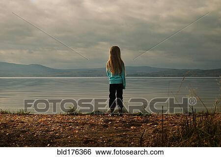 Stock Photograph - Caucasian girl standing at lake. Fotosearch