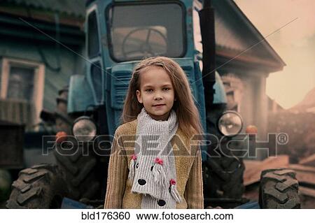 Caucasian girl standing near tractor View Large Photo Image Stock Image - Caucasian girl standing near tractor. Fotosearch