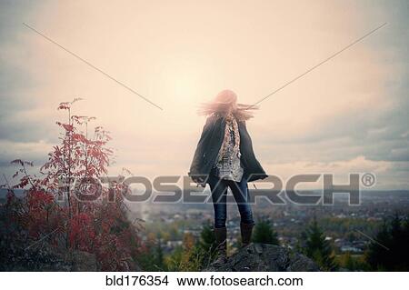 Picture - Caucasian girl standing on hilltop. Fotosearch