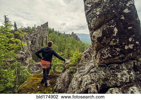 Stock Image - Caucasian hiker admiring view from hilltop. Fotosearch