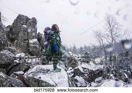 Stock Photo - Caucasian hiker standing on rocky hillside. Fotosearch