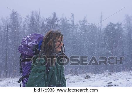 Stock Image - Caucasian hiker walking in snow. Fotosearch