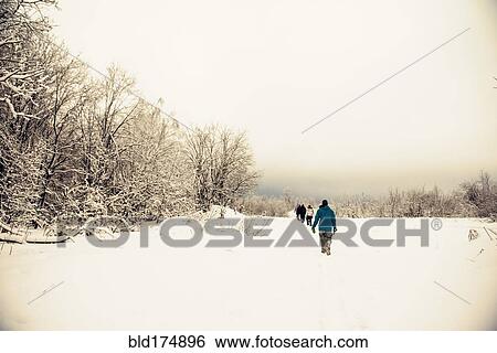 Stock Photograph - Caucasian hikers walking in snow. Fotosearch