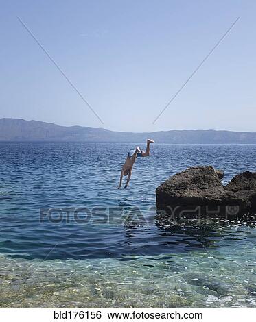 Stock Photograph - Caucasian man diving into ocean. Fotosearch