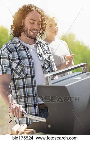 Caucasian man grilling at barbecue View Large Photo Image Picture - Caucasian man grilling at barbecue. Fotosearch