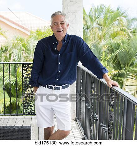 Caucasian man smiling on patio View Large Photo Image Stock Image - Caucasian man smiling on patio. Fotosearch
