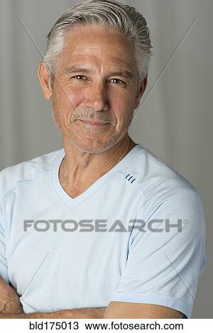 Stock Image - Caucasian man smiling with arms crossed. Fotosearch