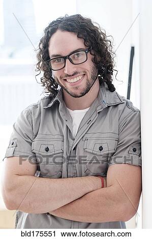 Stock Image - Caucasian man smiling with arms crossed. Fotosearch