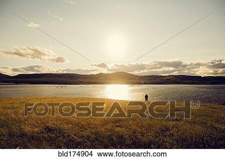 Picture - Caucasian man standing at lake. Fotosearch