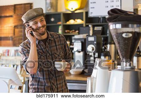 Caucasian man talking on cell phone in cafe View Large Photo Image Stock Image - Caucasian man talking on cell phone in cafe. Fotosearch