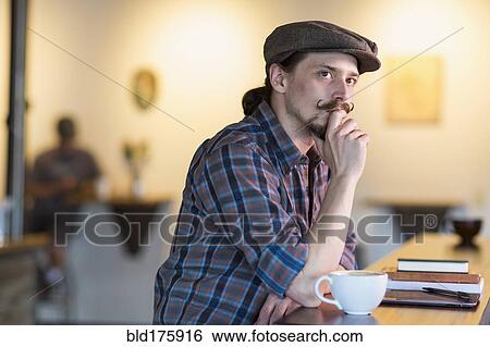 Stock Photograph - Caucasian man thinking in cafe. Fotosearch