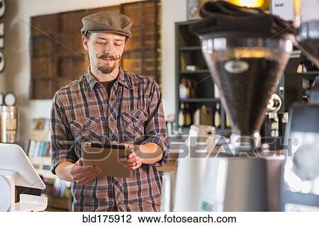 Caucasian man using digital tablet in cafe View Large Photo Image Stock Image - Caucasian man using digital tablet in cafe. Fotosearch