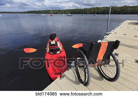 Stock Photography - Caucasian paraplegic woman rowing kayak. Fotosearch