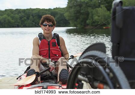 Stock Image - Caucasian paraplegic woman sitting in kayak. Fotosearch