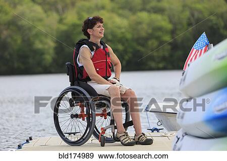 Caucasian paraplegic woman sitting on dock View Large Photo Image Stock Photo - Caucasian paraplegic woman sitting on dock. Fotosearch