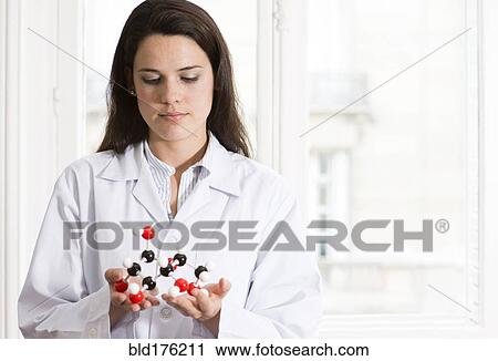 Stock Image - Caucasian scientist examining molecular model. Fotosearch