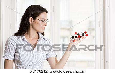 Stock Image - Caucasian scientist examining molecular model. Fotosearch