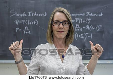 Stock Photograph - Caucasian teacher cheering at chalkboard. Fotosearch