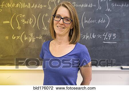 Stock Image - Caucasian teacher standing at chalkboard. Fotosearch
