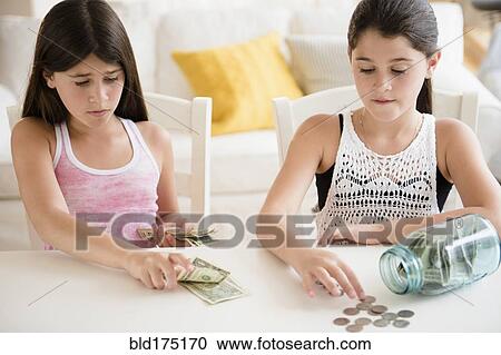 Caucasian twin sisters counting savings View Large Photo Image Stock Image - Caucasian twin sisters counting savings. Fotosearch