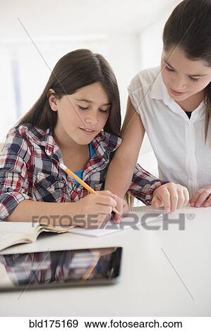 Stock Photo - Caucasian twin sisters doing homework. Fotosearch