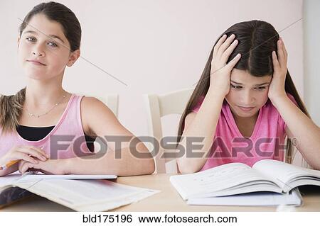Stock Photograph - Caucasian twin sisters doing homework. Fotosearch