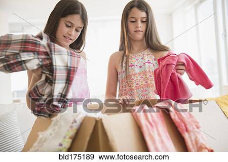 Caucasian twin sisters donating clothing View Large Photo Image Stock Photo - Caucasian twin sisters donating clothing. Fotosearch