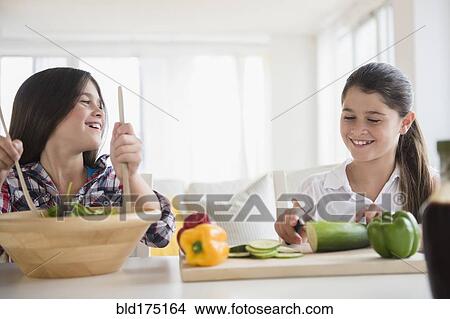Caucasian twin sisters preparing salad View Large Photo Image Picture - Caucasian twin sisters preparing salad. Fotosearch