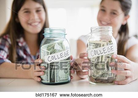 Caucasian twin sisters saving for college View Large Photo Image Stock Photo - Caucasian twin sisters saving for college. Fotosearch